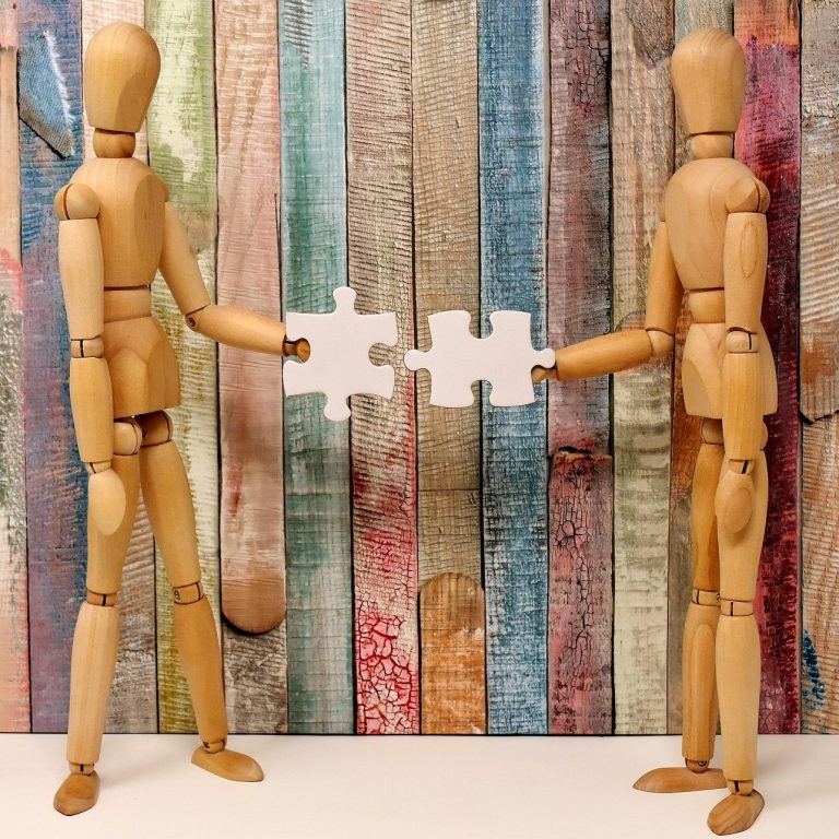 https://pixabay.com/users/alexas_fotos-686414/ Two wooden mannequins exchange puzzle pieces against a colourful wooden backdrop.
